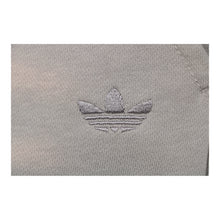 Calça Adidas Originals Trefoil Cinza-Claro - detalhe do bordado Trefoil
