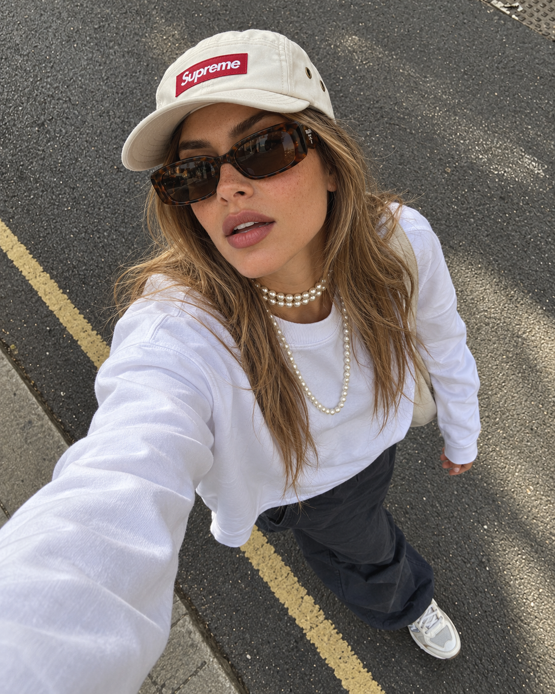 Editorial feminino KOA com boné Supreme e óculos escuros