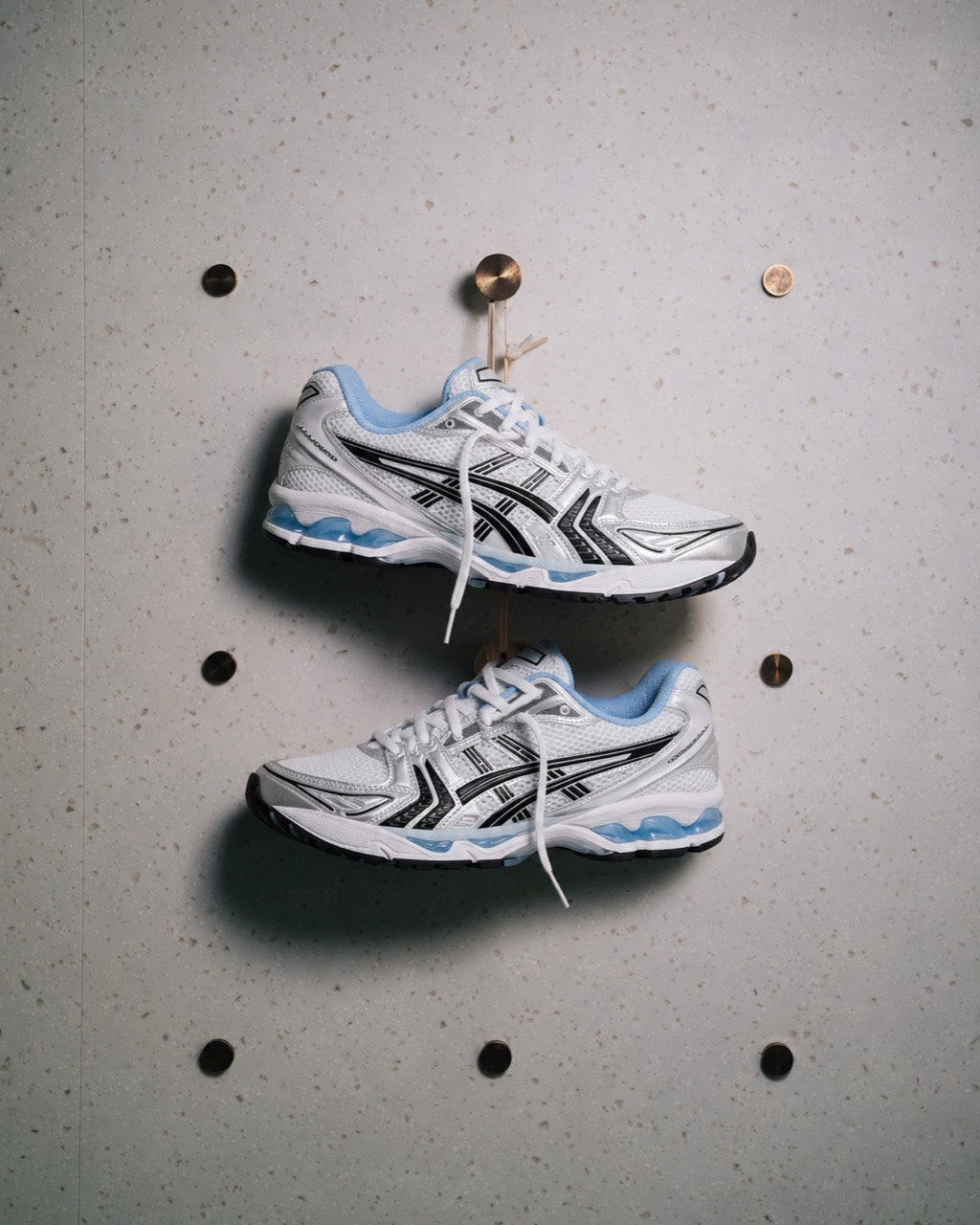 Dois tênis ASICS brancos e azuis em fotografia editorial